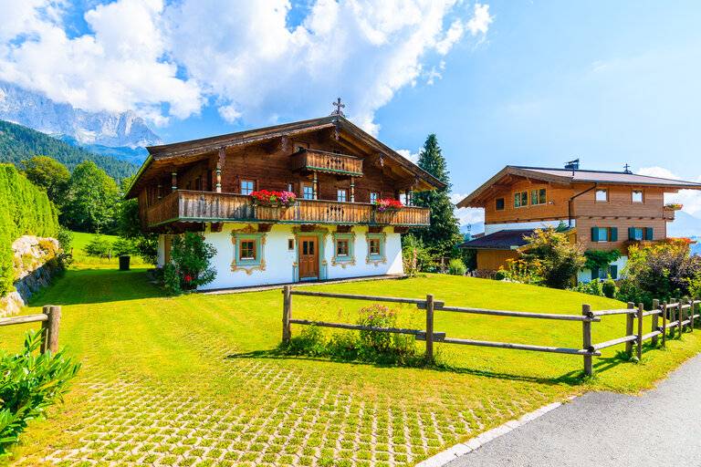 Traditionelle Alpenhäuser im Dorf Going am Wilden Kaiser an einem schönen sonnigen Sommertag, Tirol, Österreich