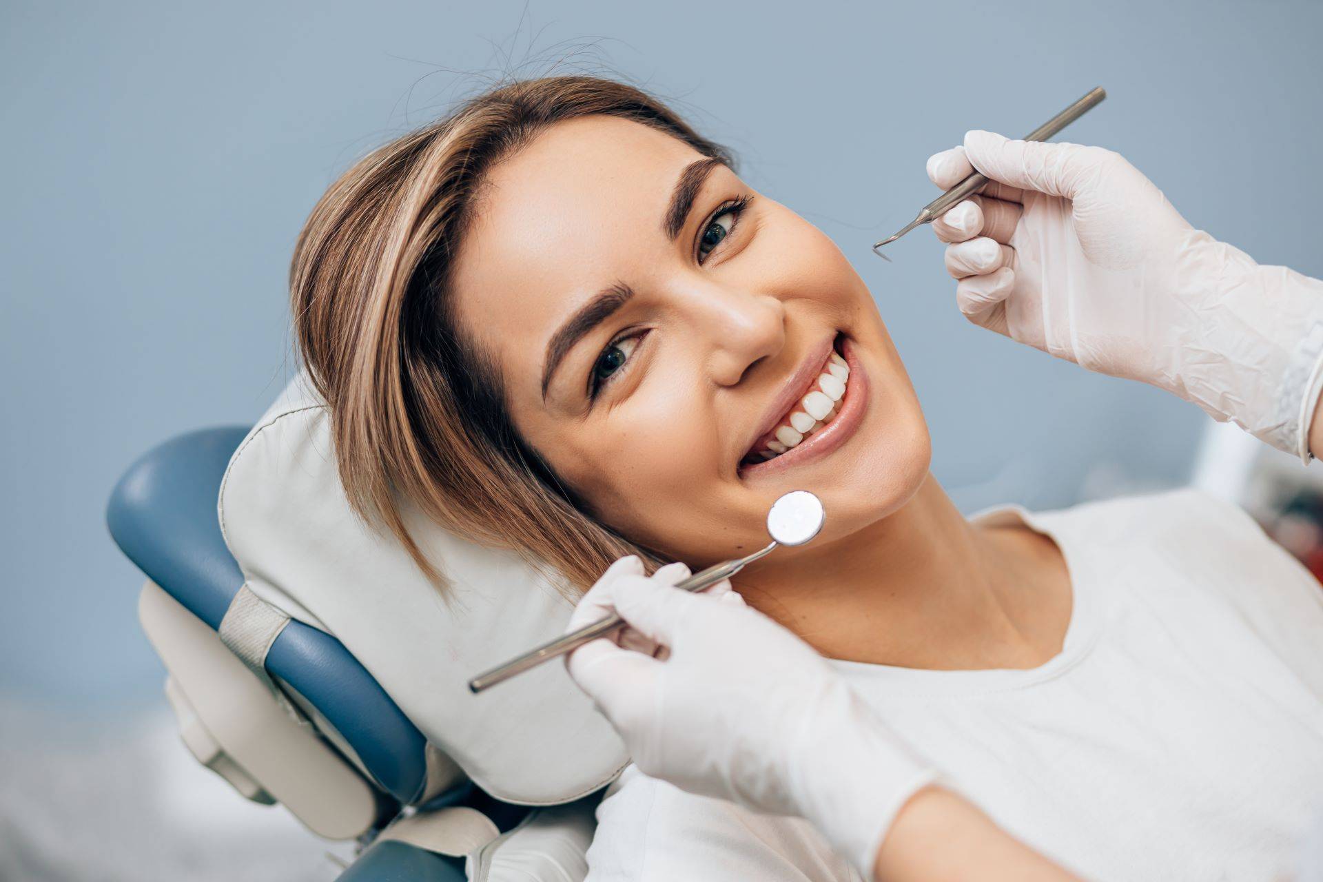 Frau mit Lächelm beim Zahnarzt
