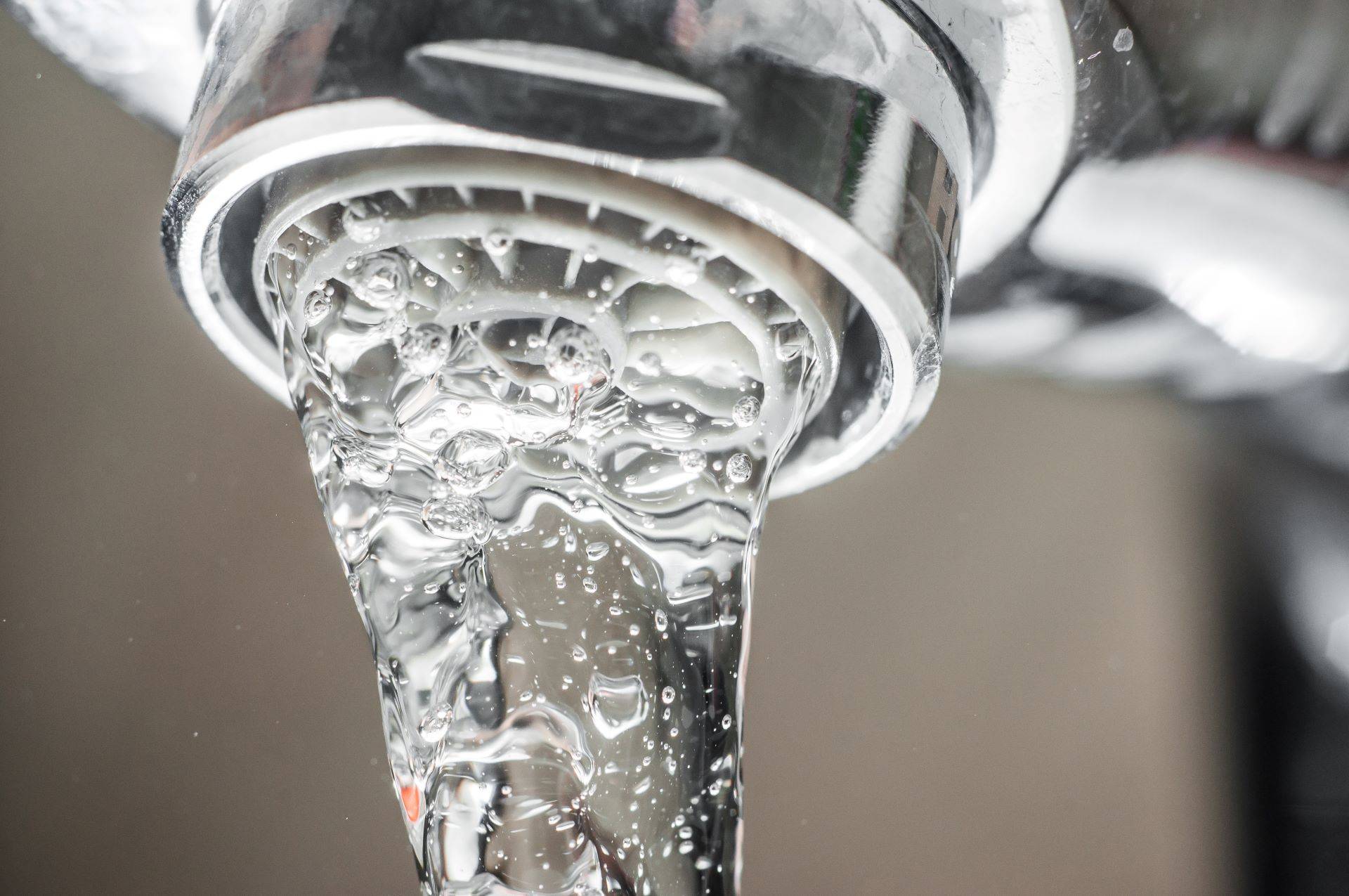 Klares Wasser fließt aus einem modernen Wasserhahn