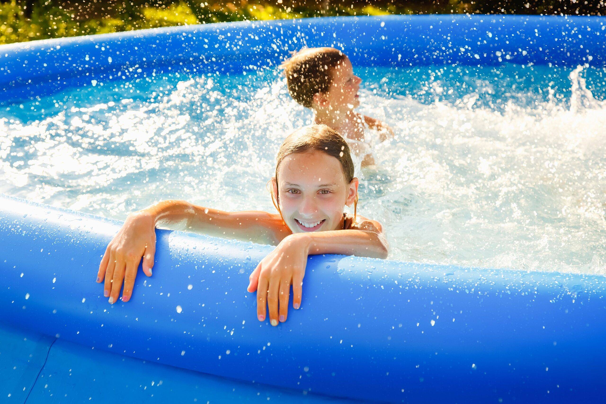 Pools kaufen: Kinder planschen in einem Aufstellpool im Garten