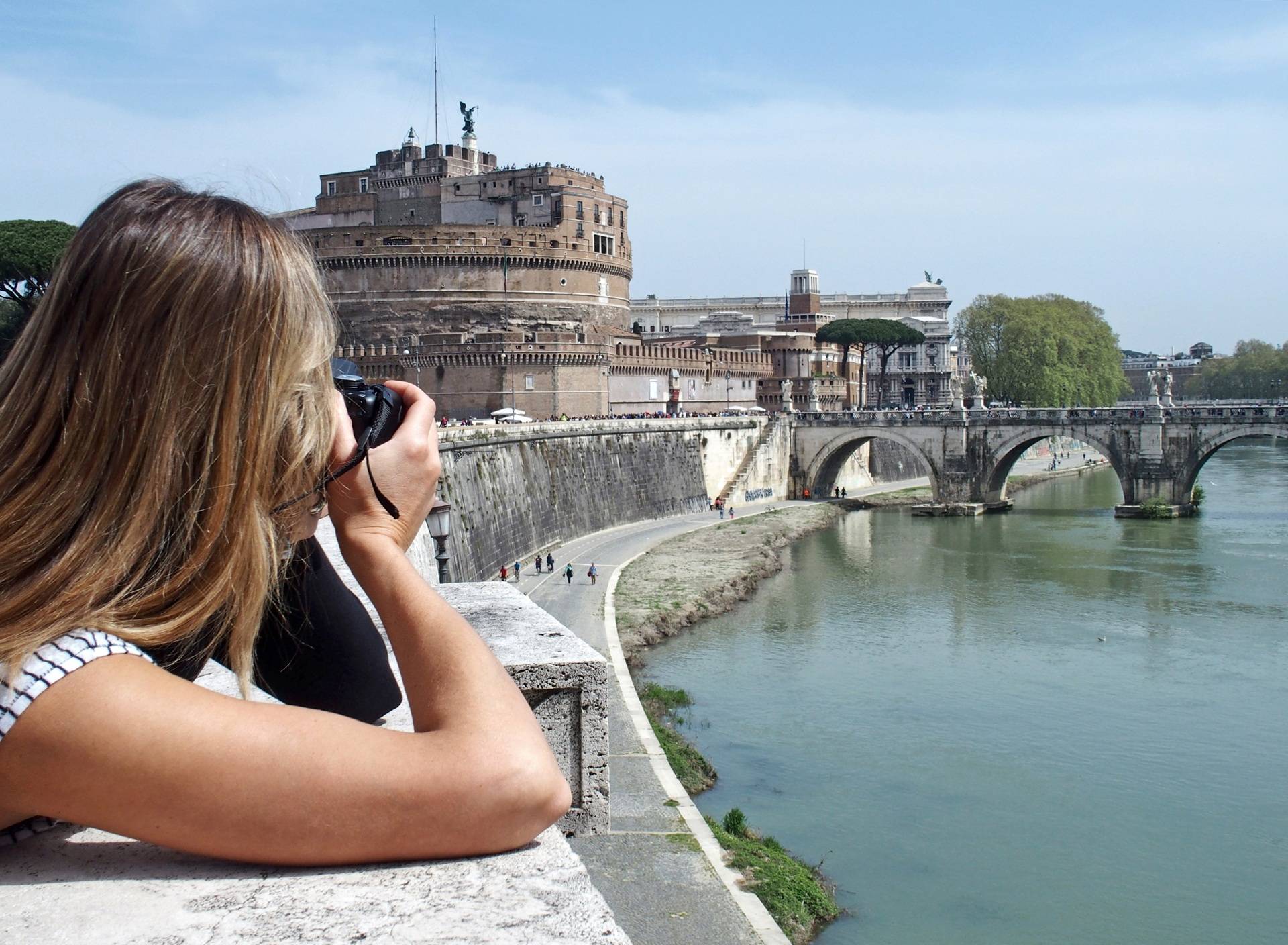 Frau fotografiert historisches Bauwerk am Fluss | E Liquid