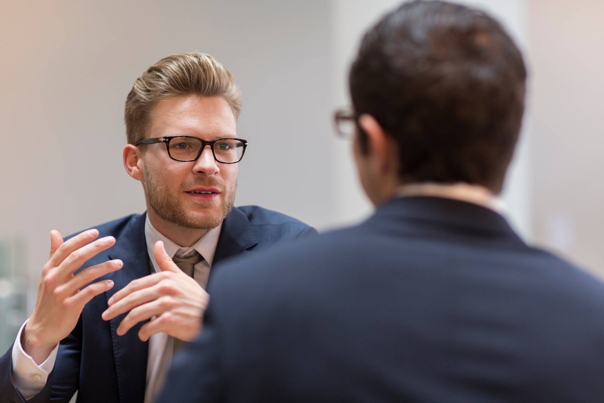 Geschäftsmann erklärt mit Gestik im Gespräch | Einkauf Verhandlungsstrategien