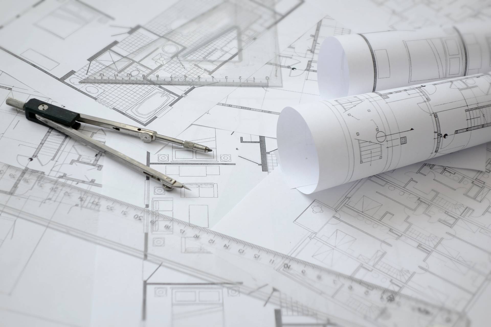 Architektenplaene mit Zirkel auf Tisch | modulares Bauen

