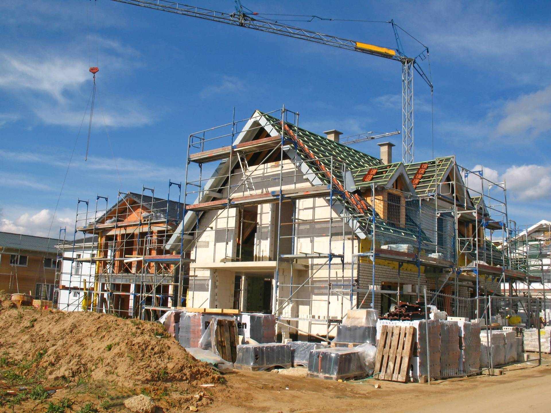 Hausbau mit Geruesten und Kran auf Baustelle | modulares Bauen