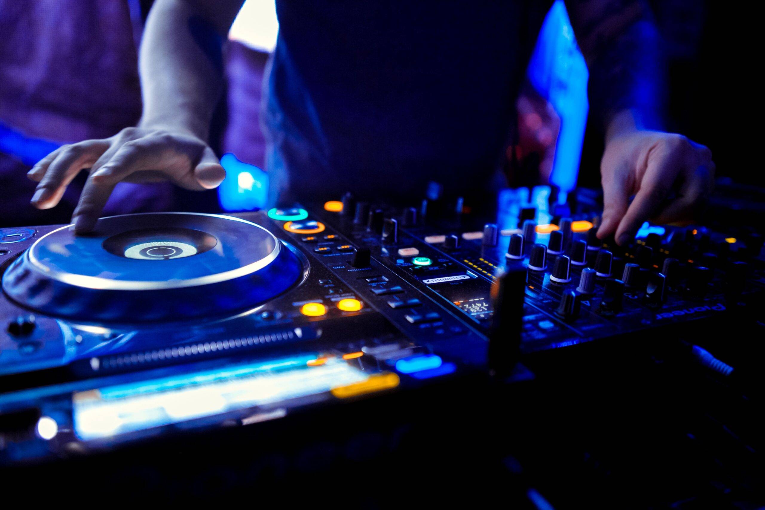 Hochzeits DJ Berlin legt live auf einem professionellen DJ-Mischpult auf, mit stimmungsvoller Lichttechnik im Hintergrund