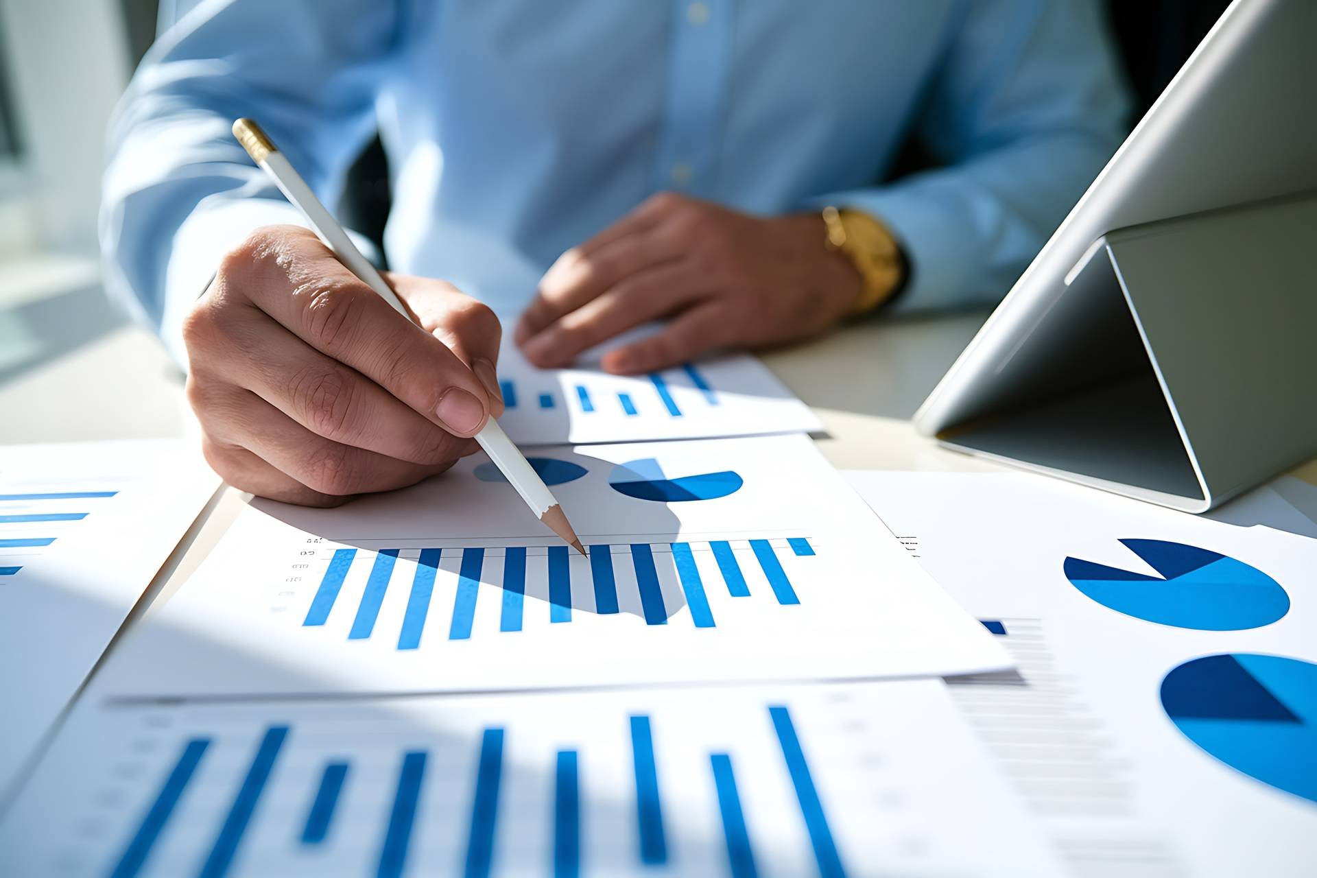 and zeigt mit Stift auf Wirtschaftsdaten und Diagramme | Heizölpreise Mannheim